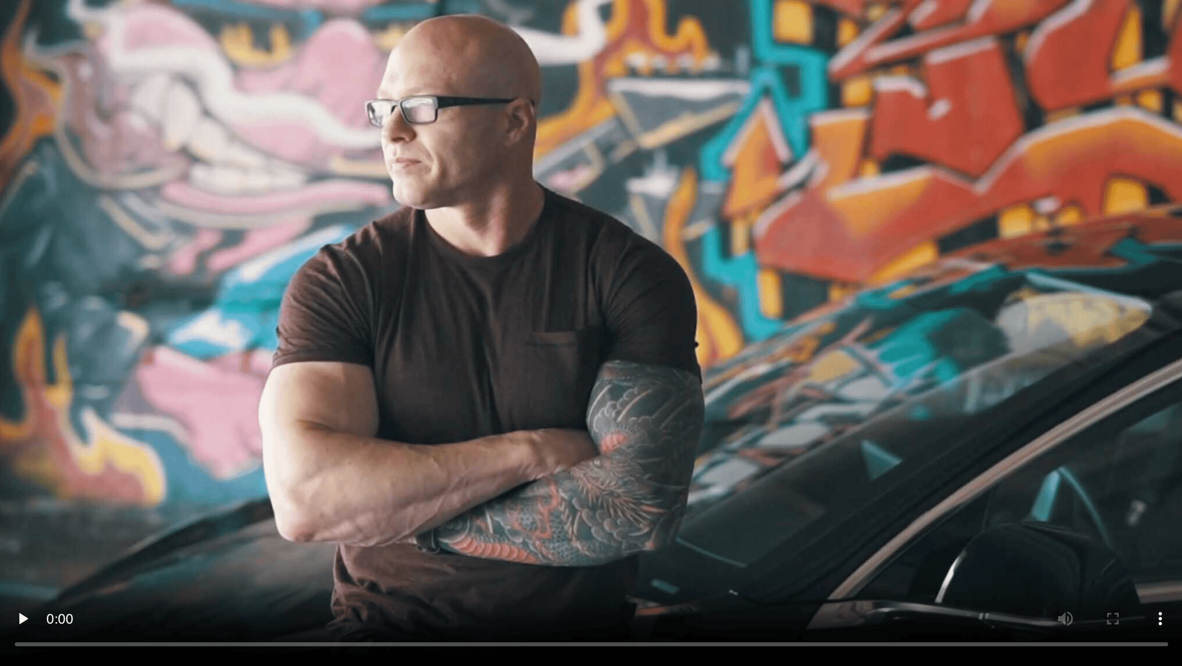 Legion Corporation CEO, Joe Shelley, with arms folded in front of security vehicle.